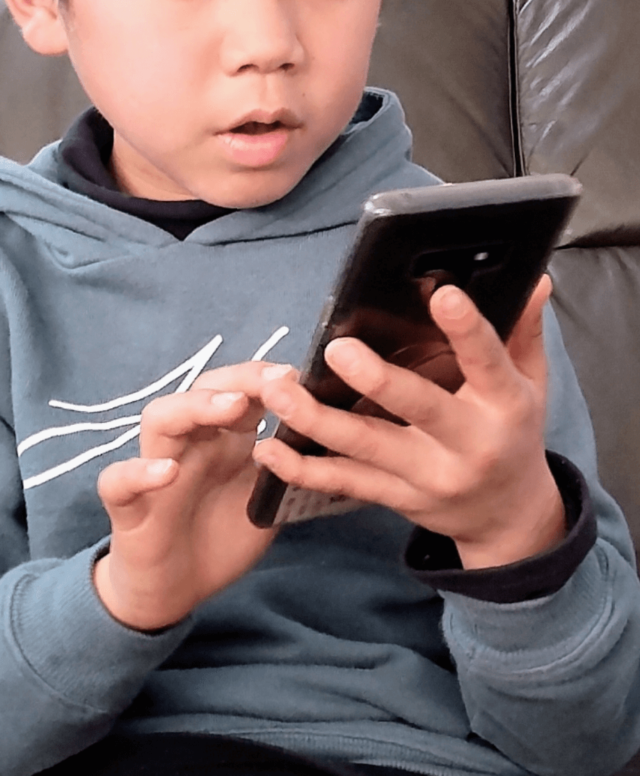 スマートフォンを操作する子供