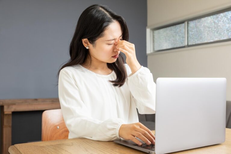 目頭を抑える女性
